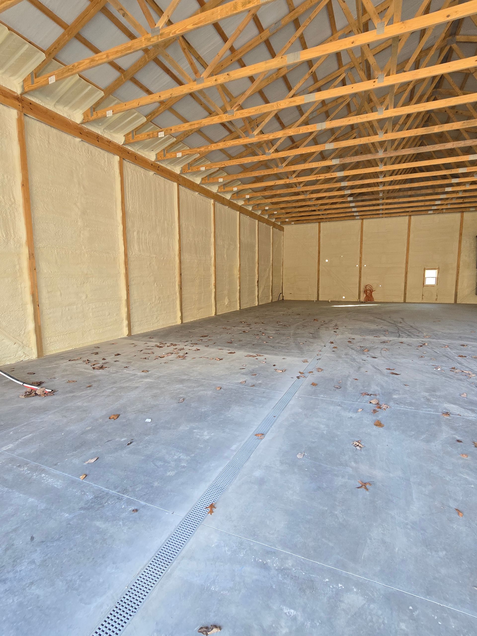 A large empty room with a wooden ceiling and a concrete floor