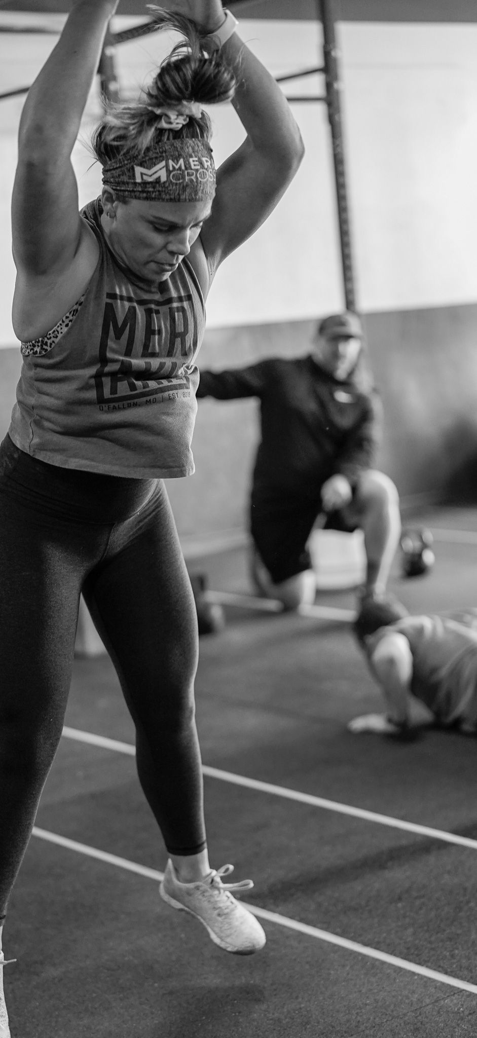 Person jumping rope in a gym, with another person exercising in the background.
