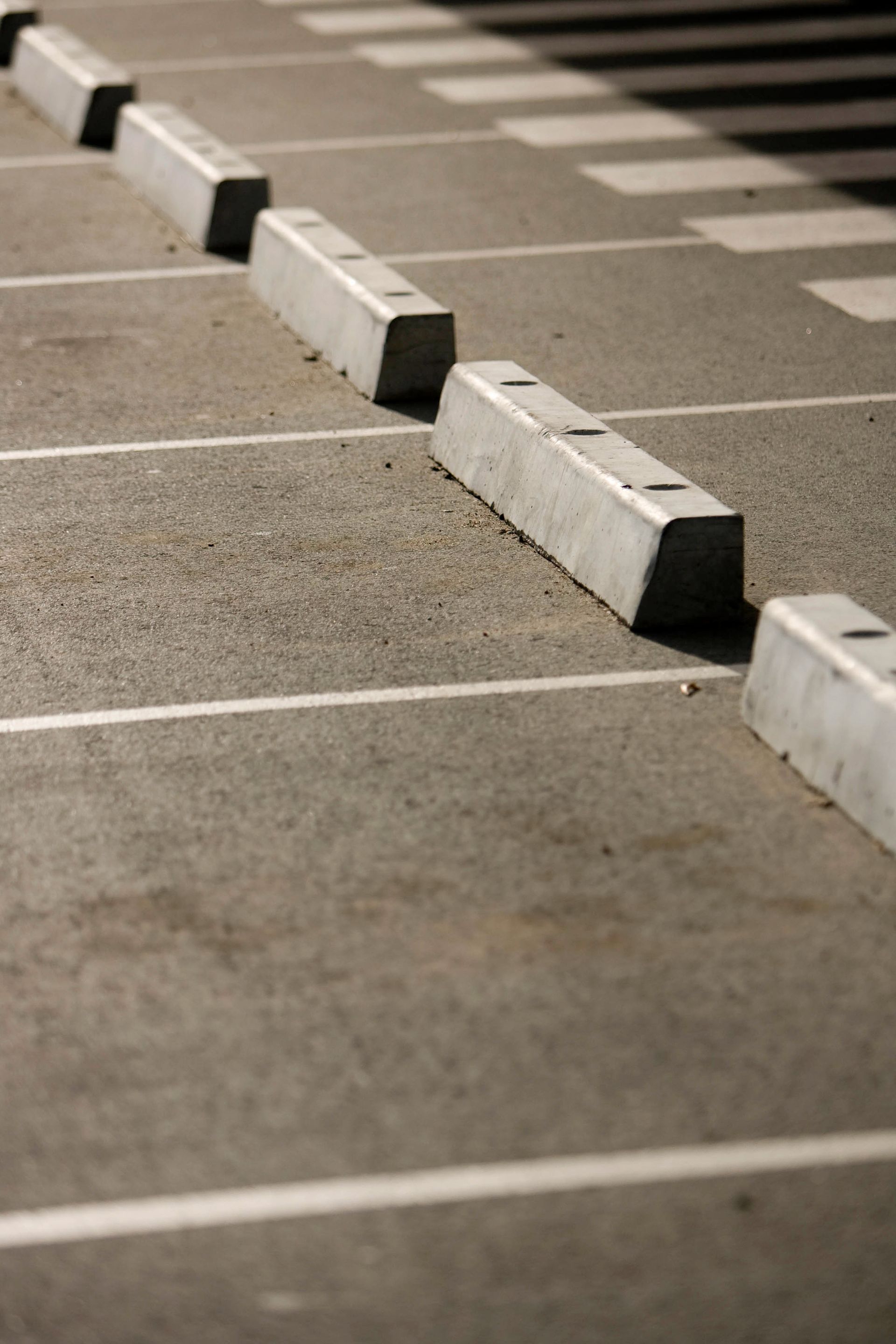 Empty parking lot with white space lines and concrete wheel stops