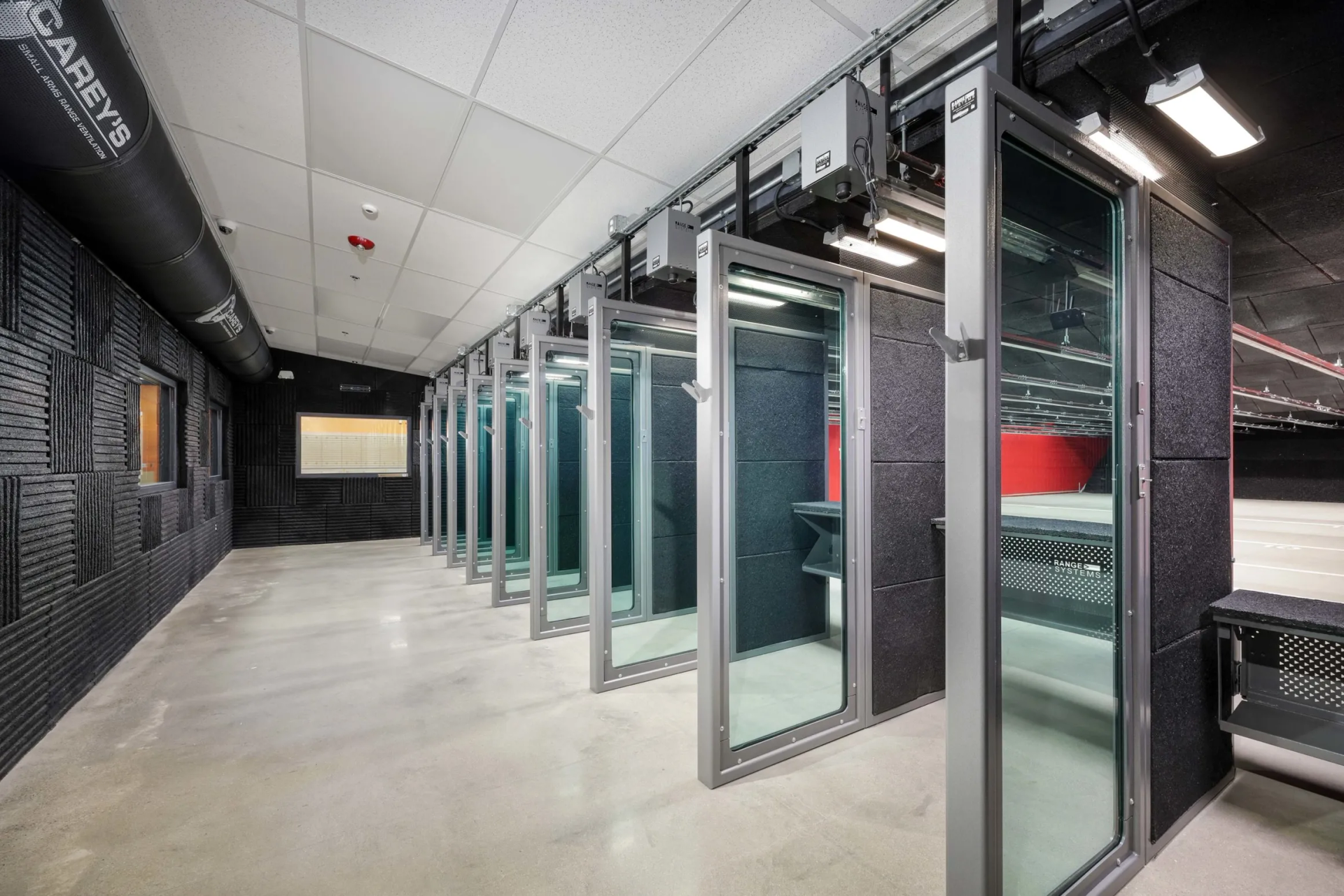 Indoor shooting range with stalls, soundproofing, and concrete floor.