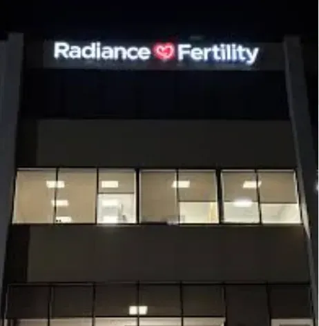 Radiance Fertility clinic building with illuminated sign at night.