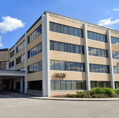 Three-story building with beige exterior, many windows, and the name Casa D'Oro on the front.
