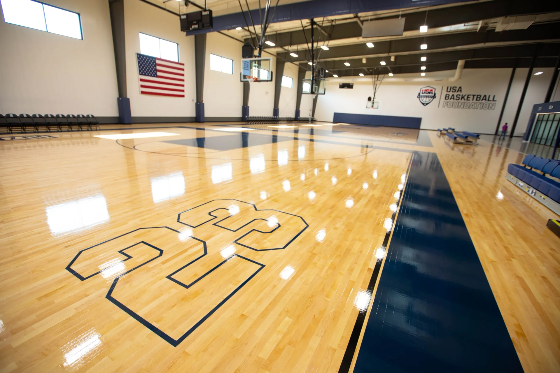 Basketball court with the number 23 painted on the floor, and an American flag on the wall.