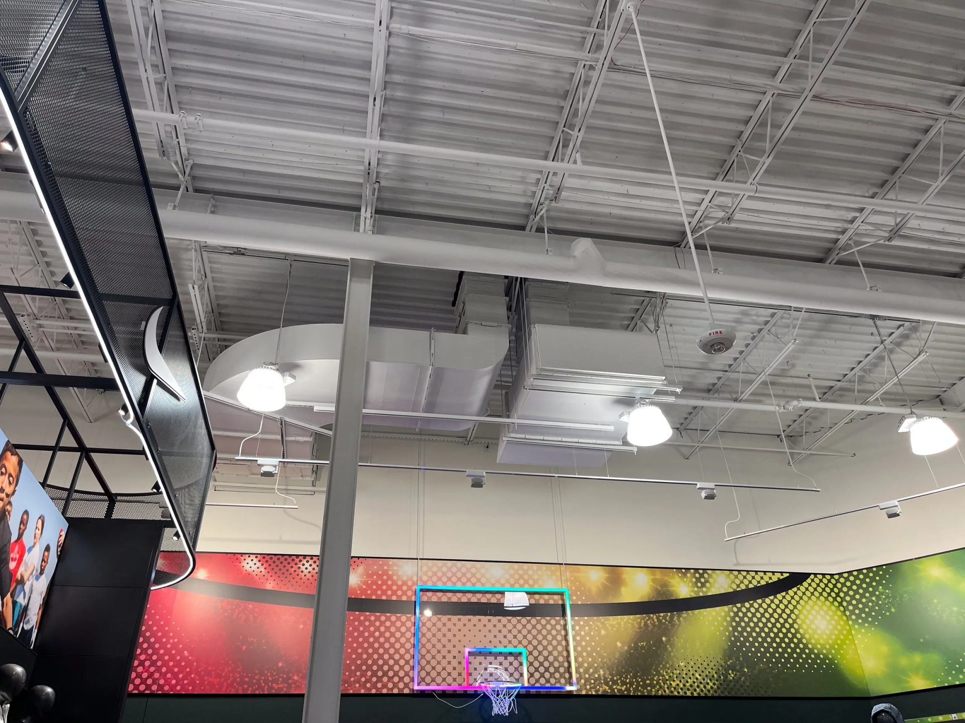 Basketball hoop indoors with a ball going through it.