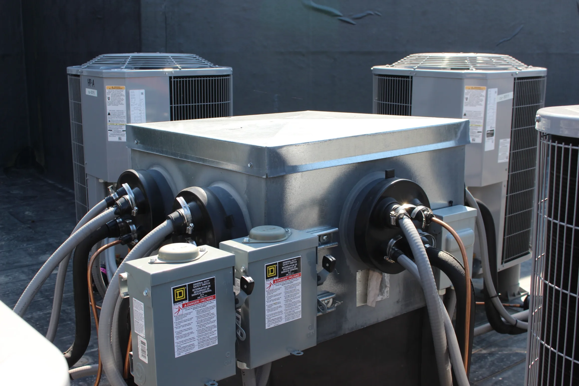 Rooftop air conditioning units with electrical connections.