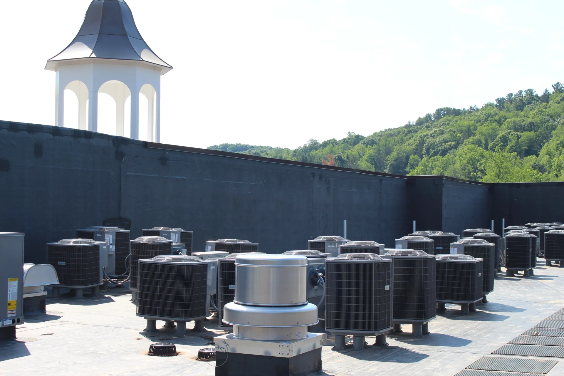 Rooftop with HVAC units and a gazebo in the background, a mountain is visible in the distance.
