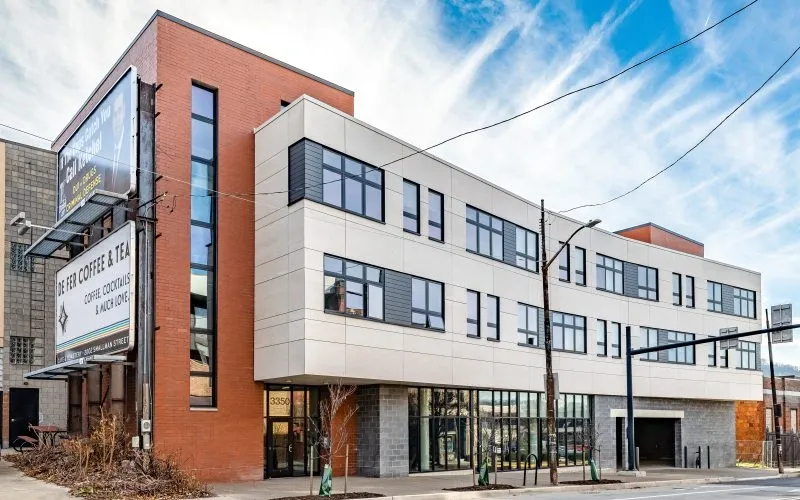 Modern building with brick and white facade; signs for a clinic are visible.