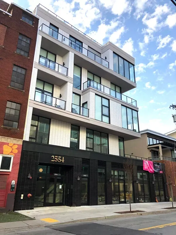 Modern apartment building with balconies, black facade, and glass windows. Located at 255.