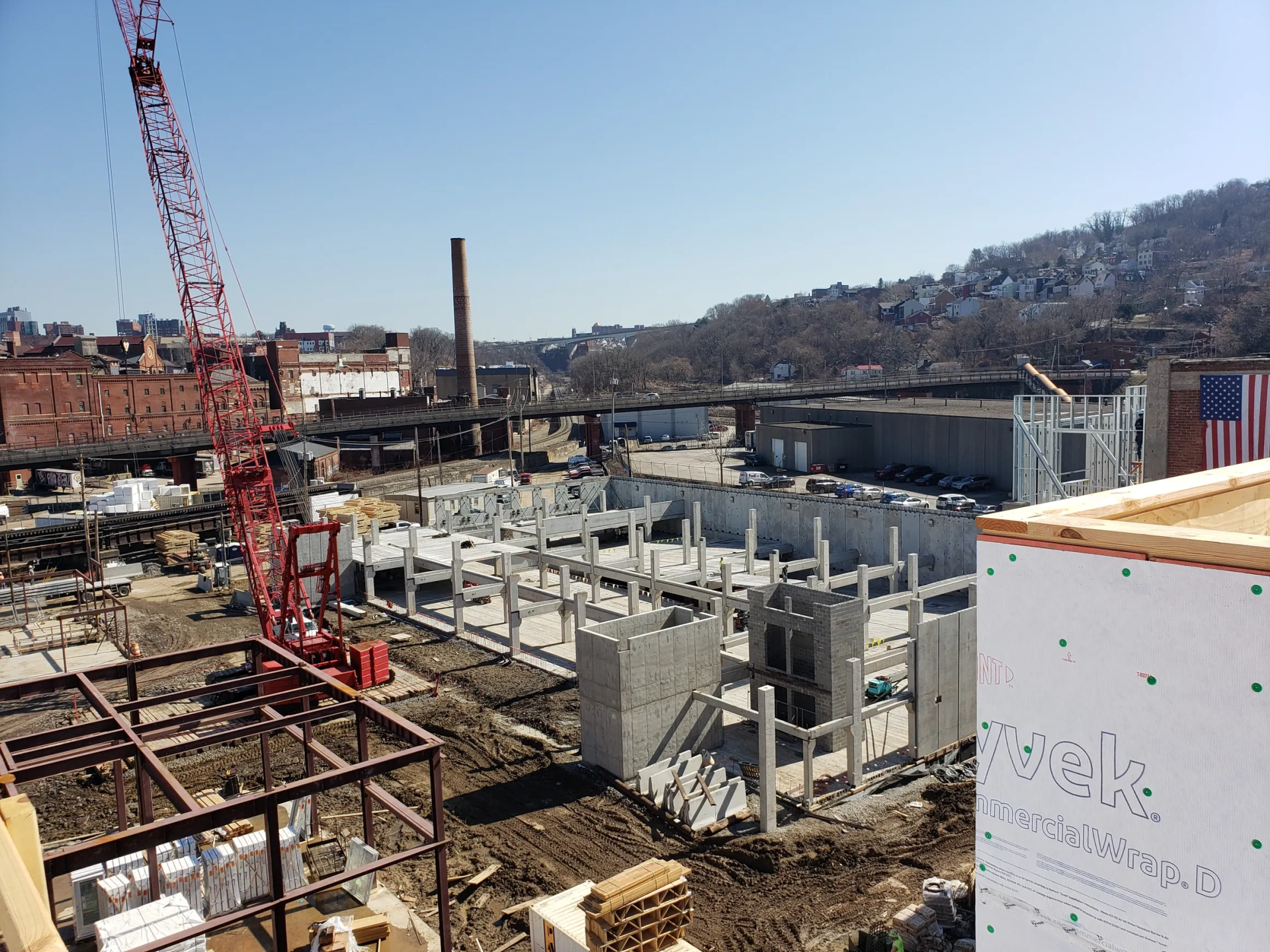 Construction site with concrete structures, crane, and partially built buildings.
