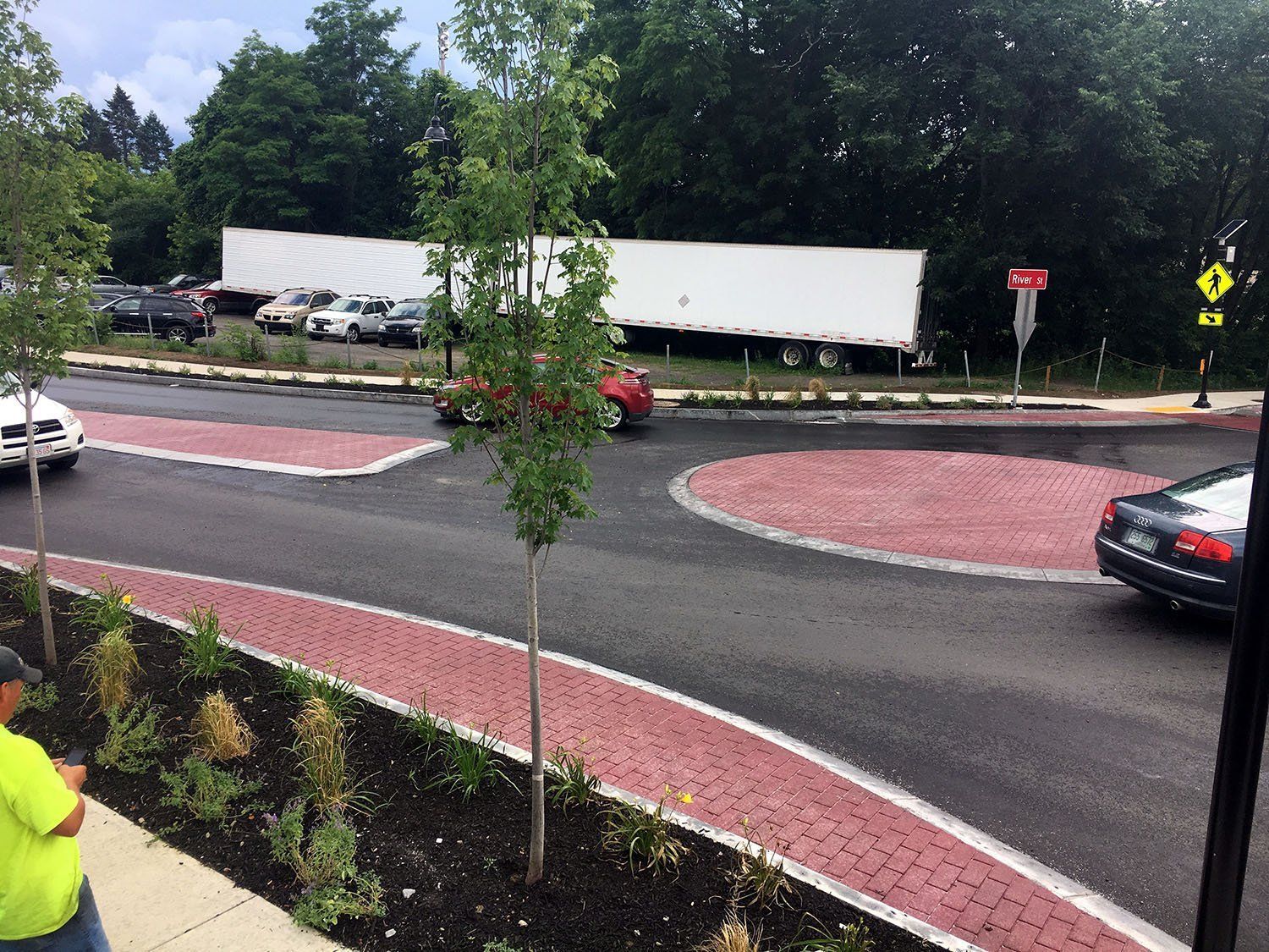 A white semi truck is driving through a roundabout