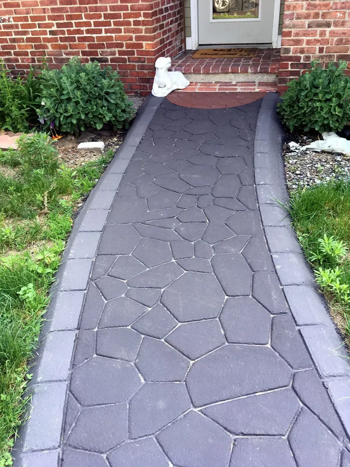 A stone walkway leading to a brick house