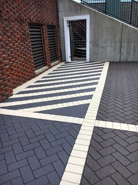 A black and white brick driveway with a staircase in the background