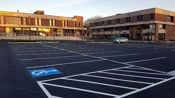 A car is parked in a handicapped parking space in front of a building.