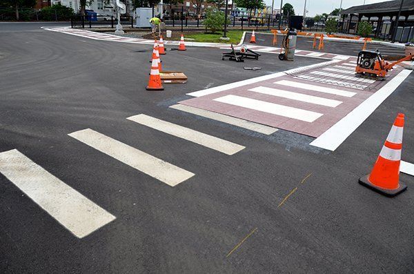 A crosswalk is being painted on the side of the road