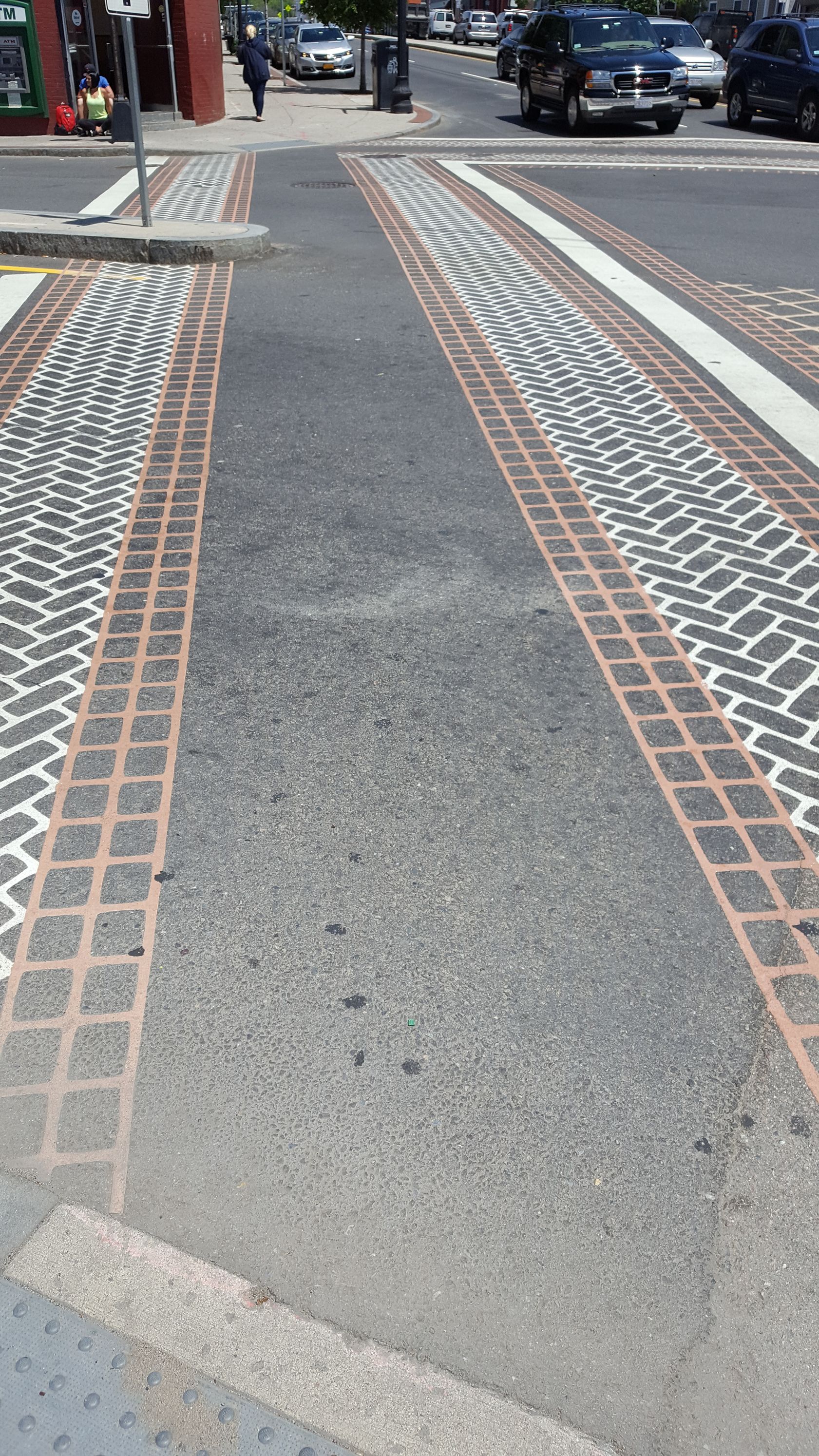 A brick walkway along the side of a street