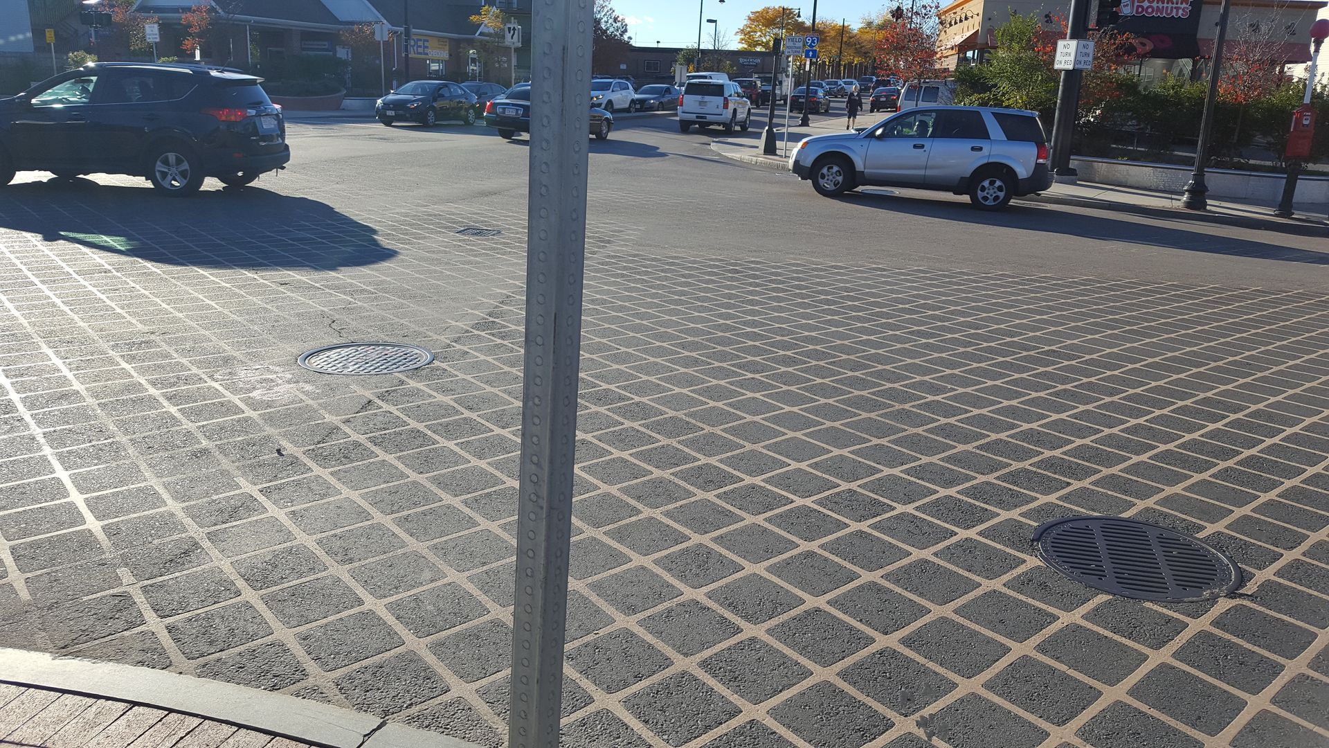 A white suv is driving down a street next to a parking meter.