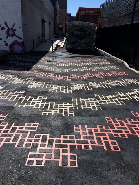A truck is parked on the side of a road with a pattern of squares painted on it