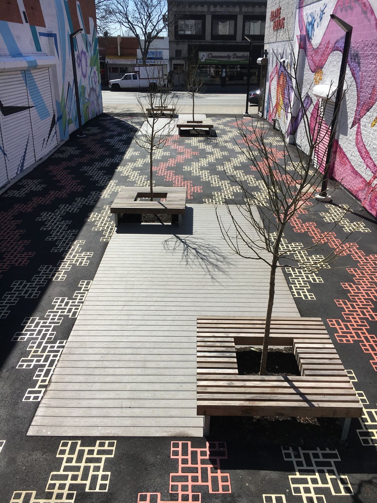 A wooden walkway with benches and a tree in the middle of it.