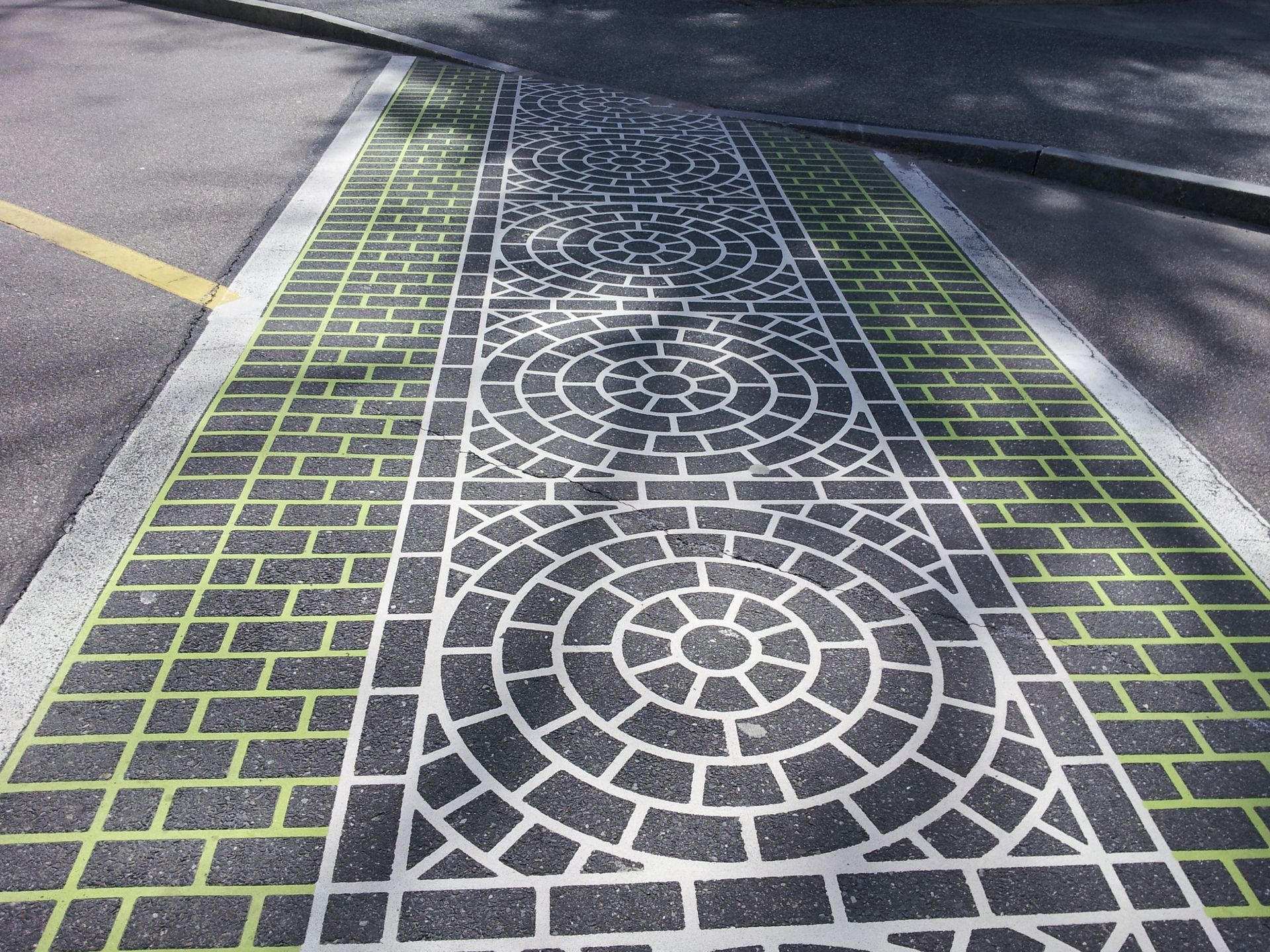 A brick walkway with a circular pattern painted on it