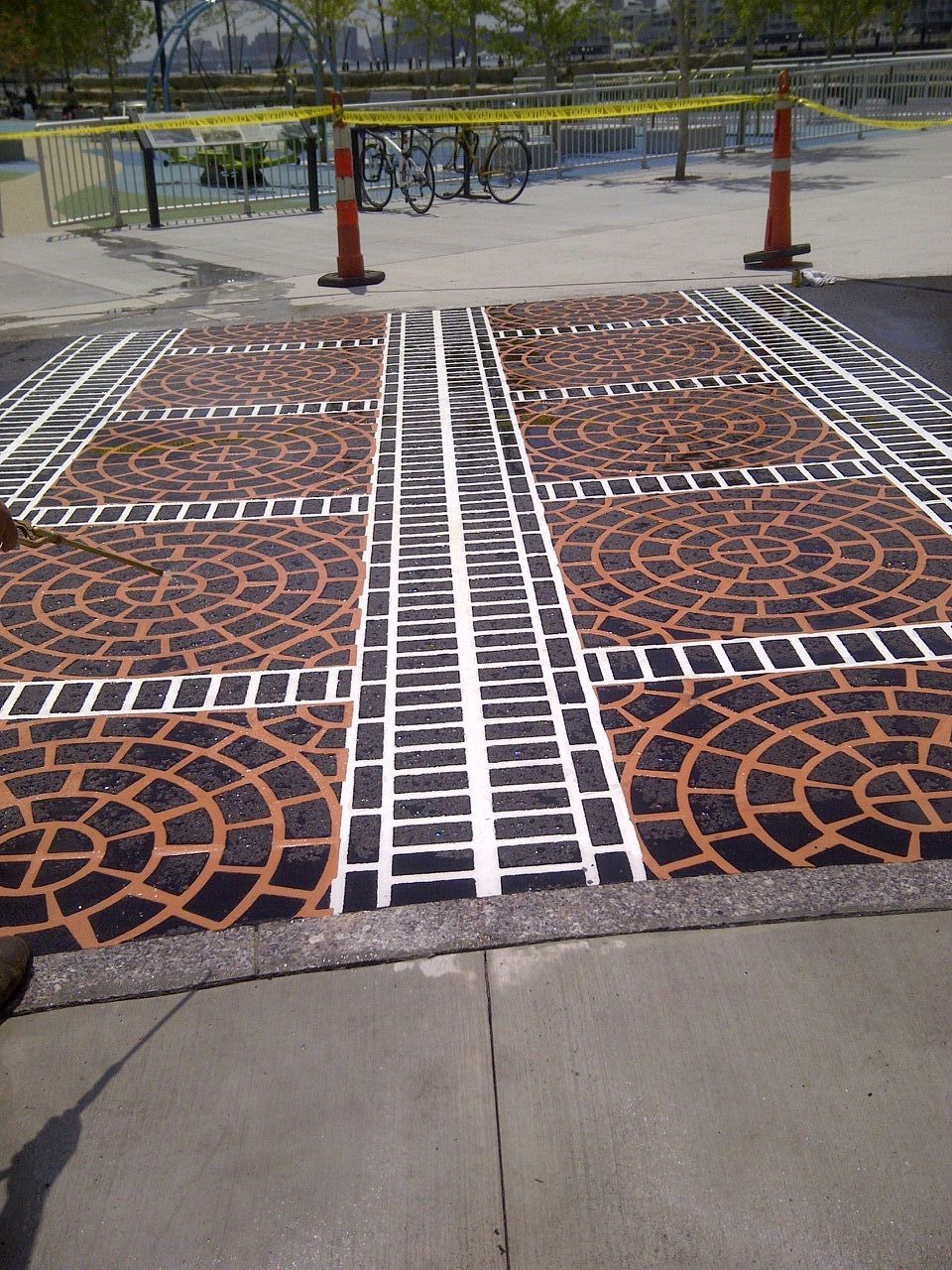 A brick walkway with train tracks painted on it