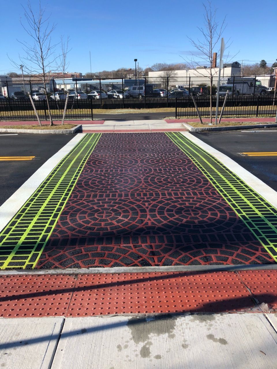 A brick walkway with a drain on the side of it