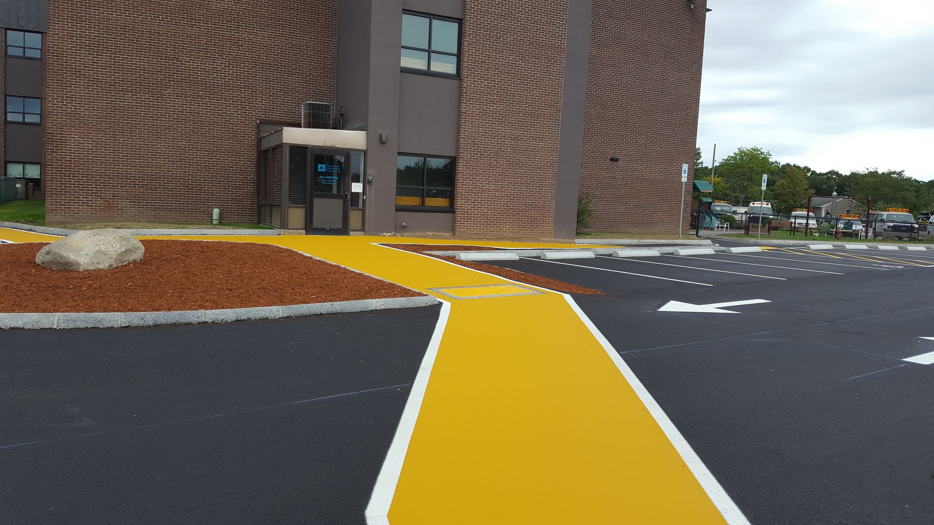 A brick building with a yellow walkway in front of it