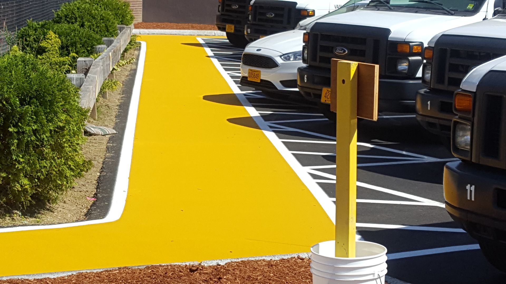A row of trucks are parked in a parking lot