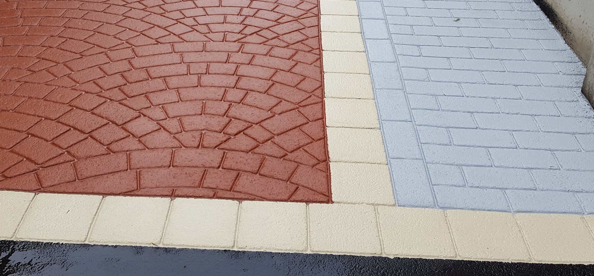 A red , white and blue brick walkway with a white border.