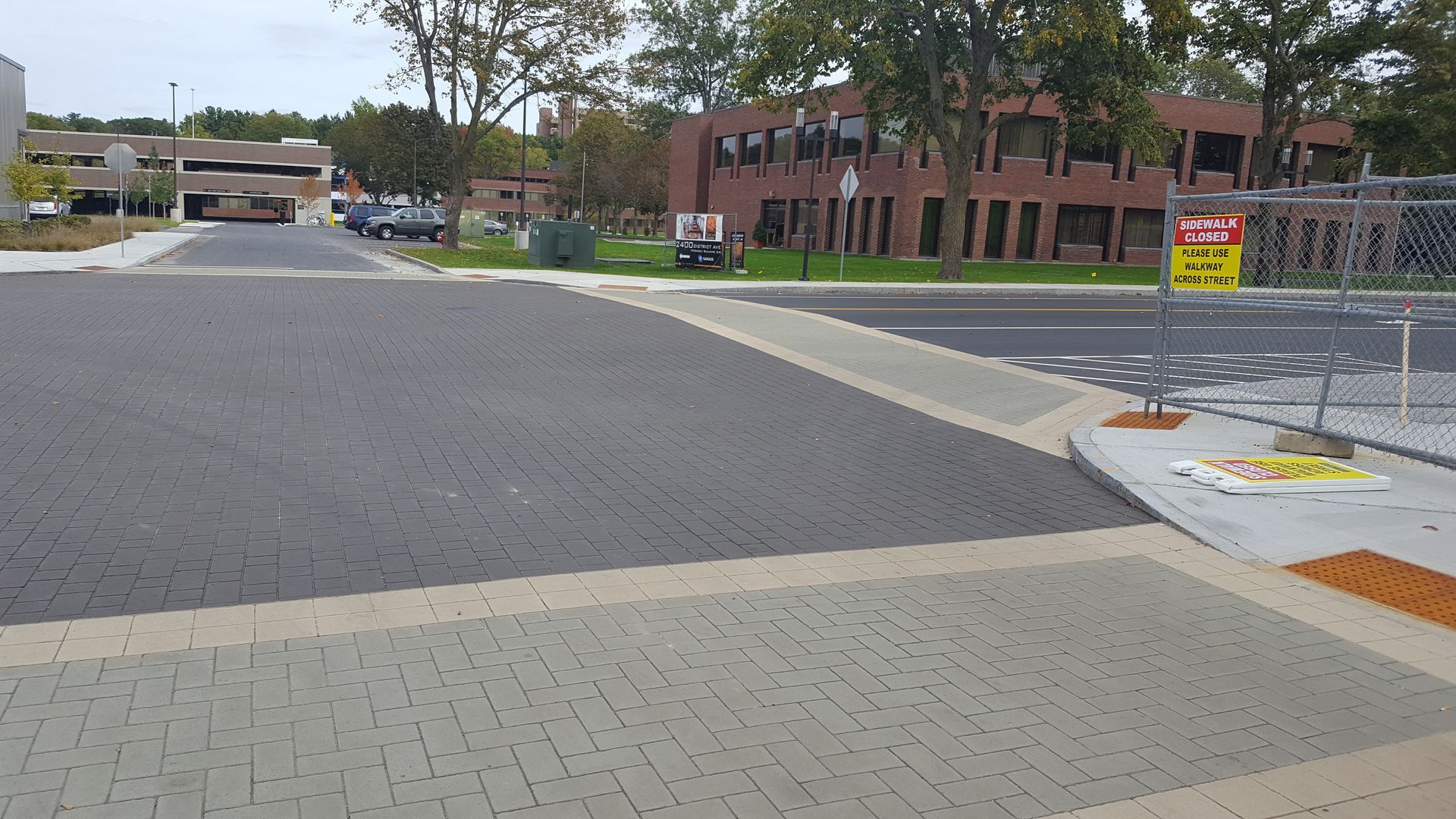 A street with a fence and a sign that says no parking