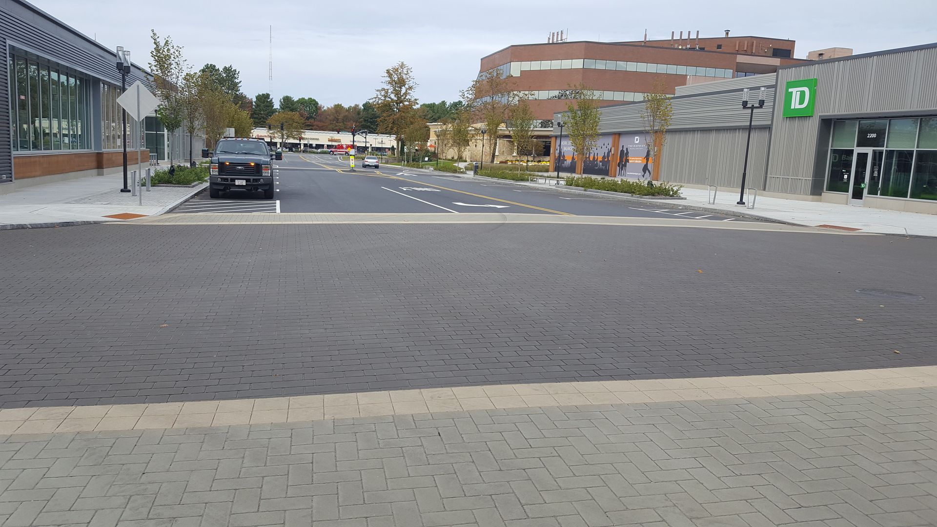 A black suv is parked on the side of the road in front of a t-mobile store
