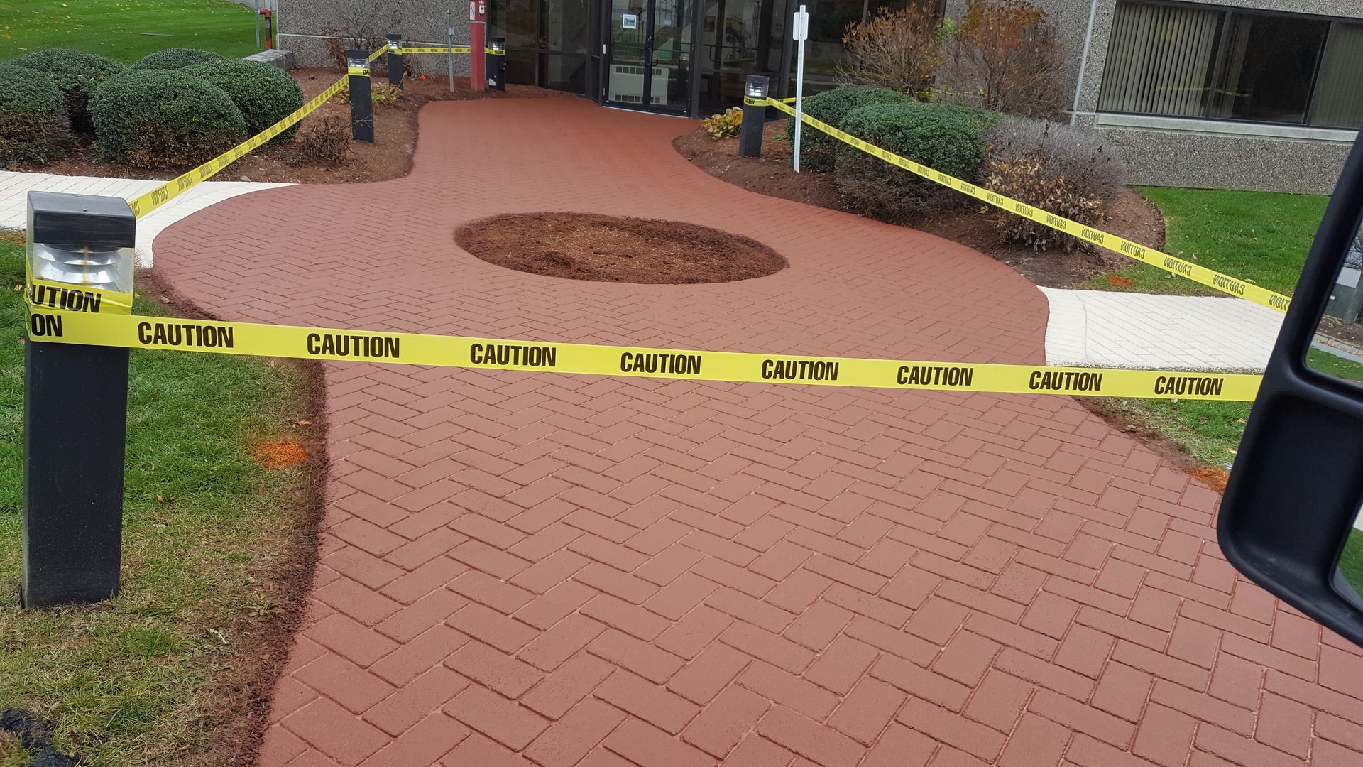 A brick walkway is surrounded by yellow caution tape.