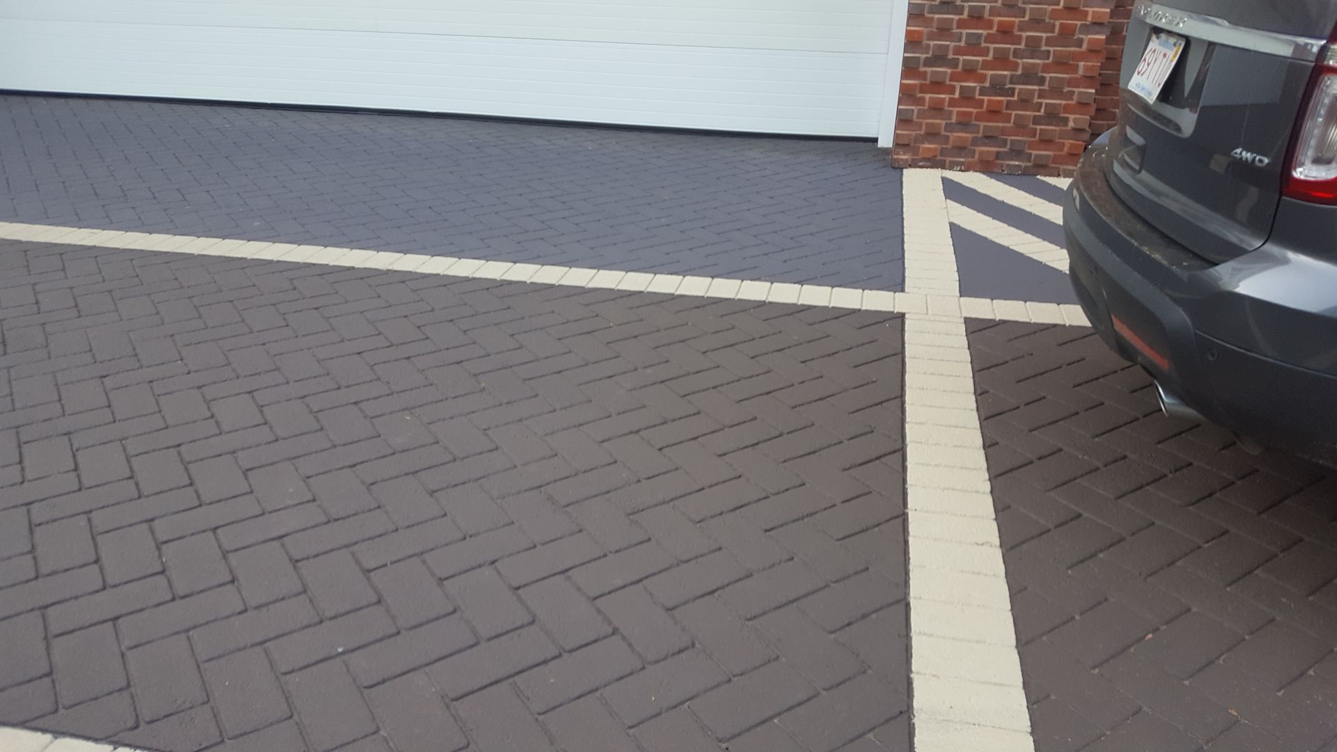 A car is parked in a parking lot next to a garage door