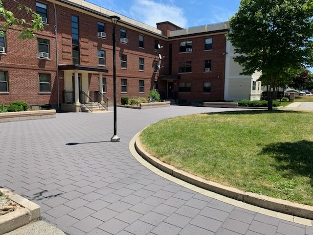 A large brick building with a circular driveway in front of it
