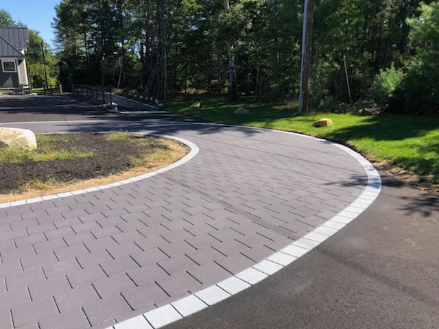 A curved driveway with a white line on the side of it.