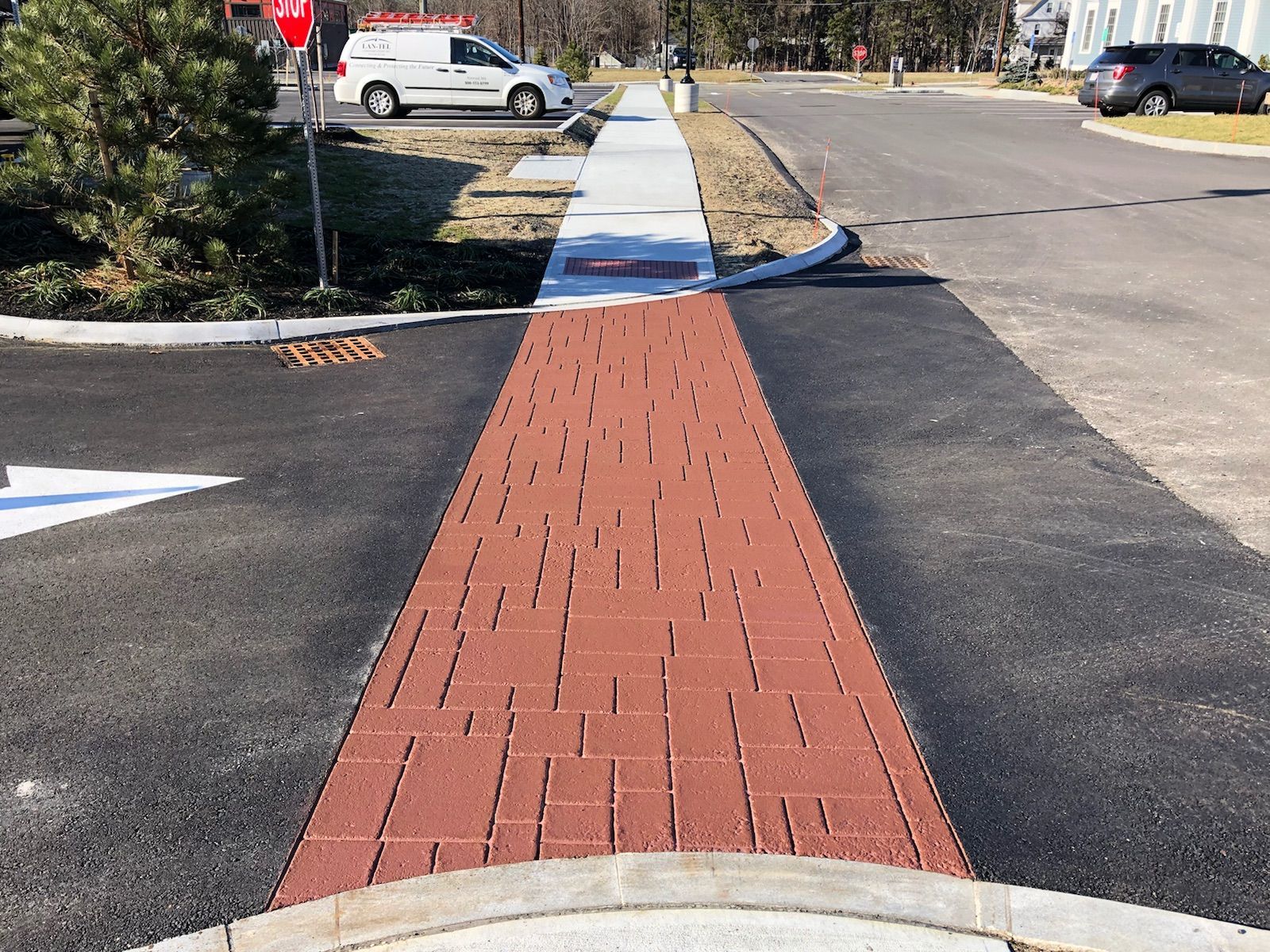 A red brick walkway leading to a parking lot