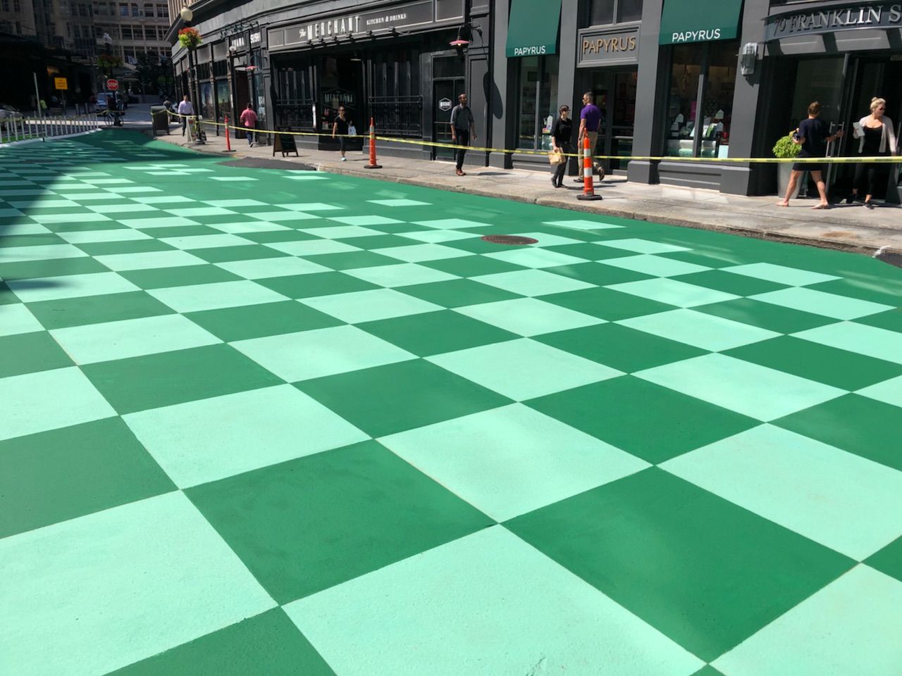 A green and white checkered floor on a city street.