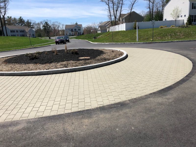 A car is driving around a roundabout in a residential area