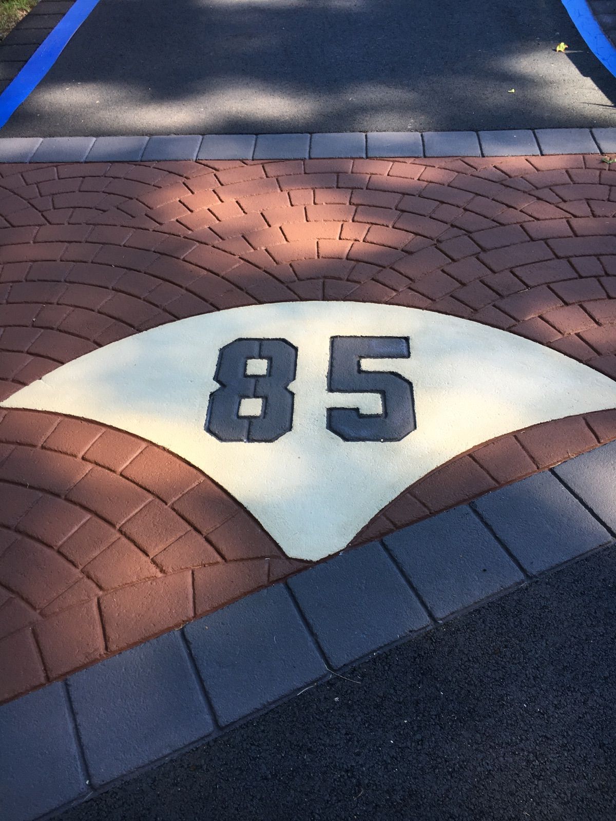 A brick walkway with the number 85 painted on it