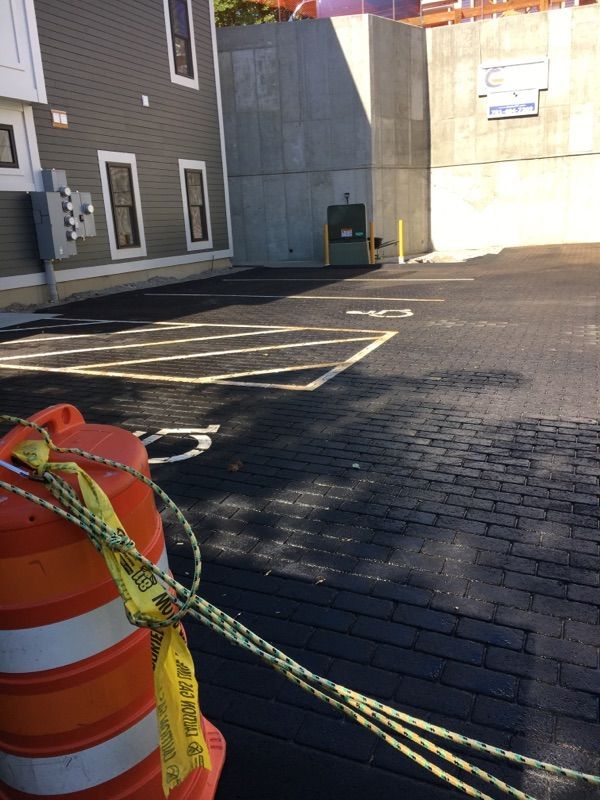 An orange cone with a yellow caution tape around it