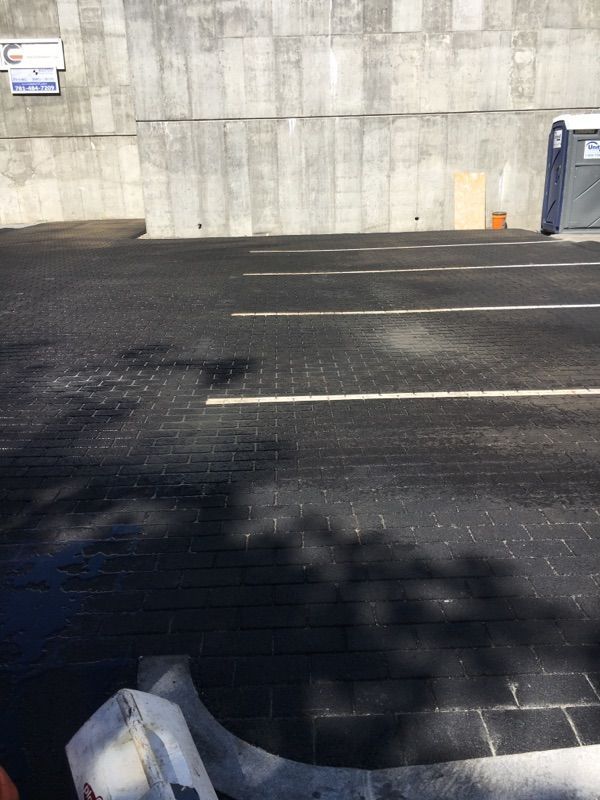 A parking lot with a concrete wall in the background.