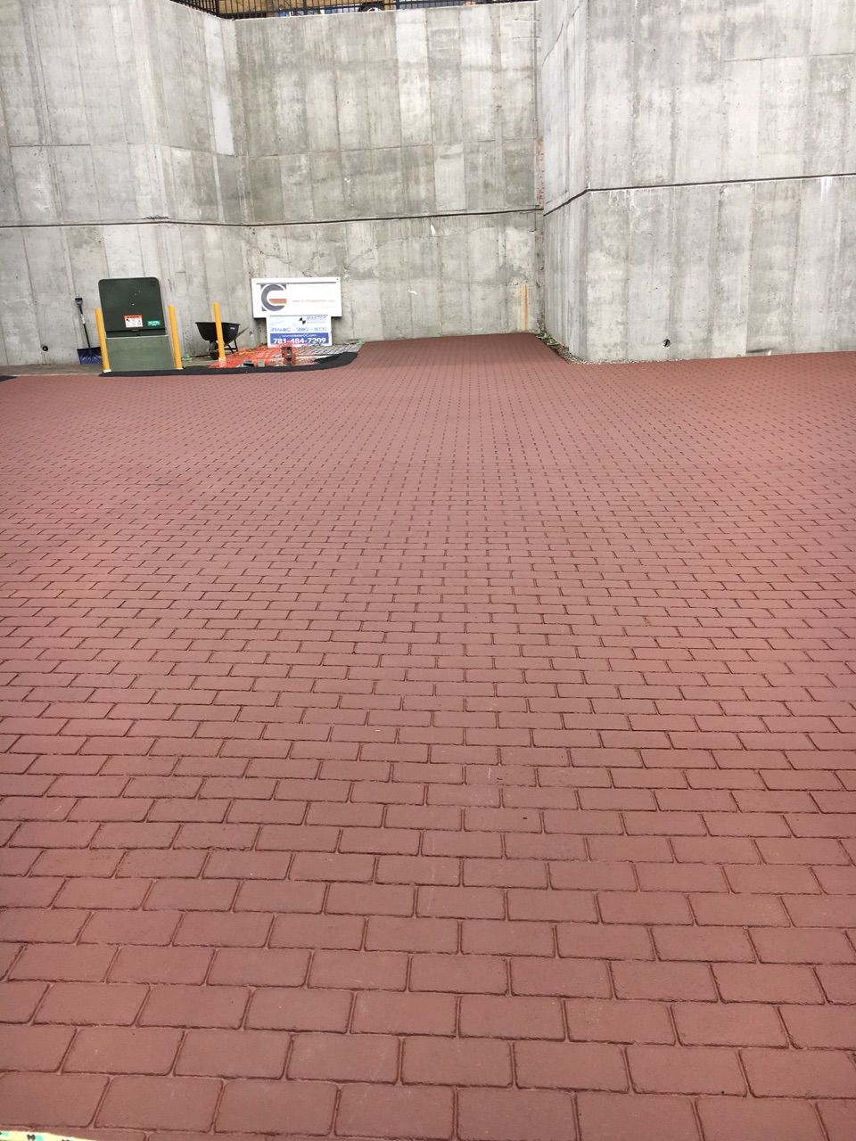 A red brick floor with a concrete wall in the background