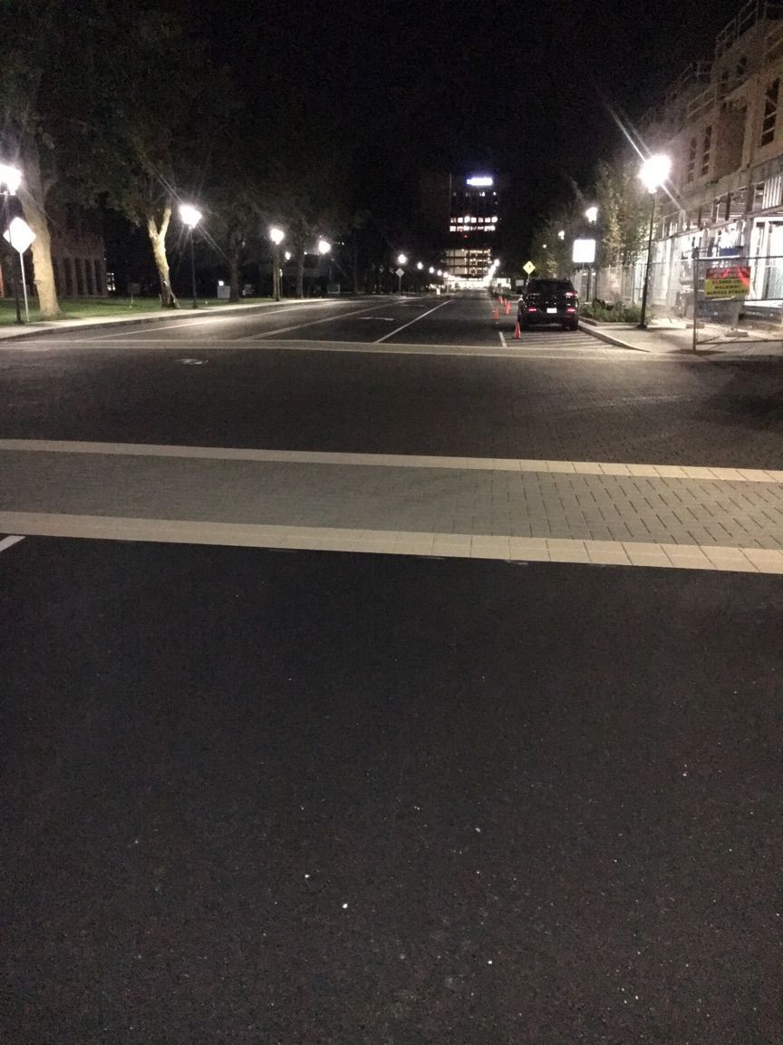 A street at night with a crosswalk in the middle