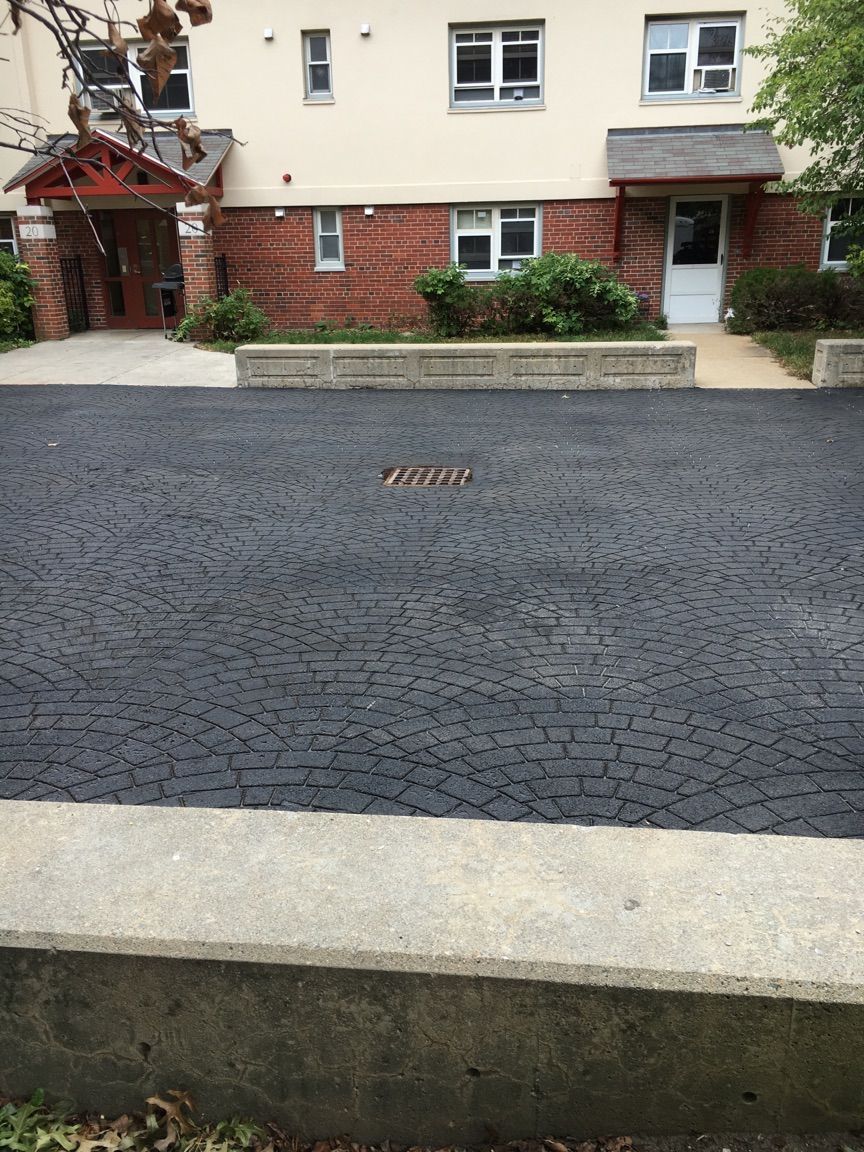 A brick building with a black driveway in front of it