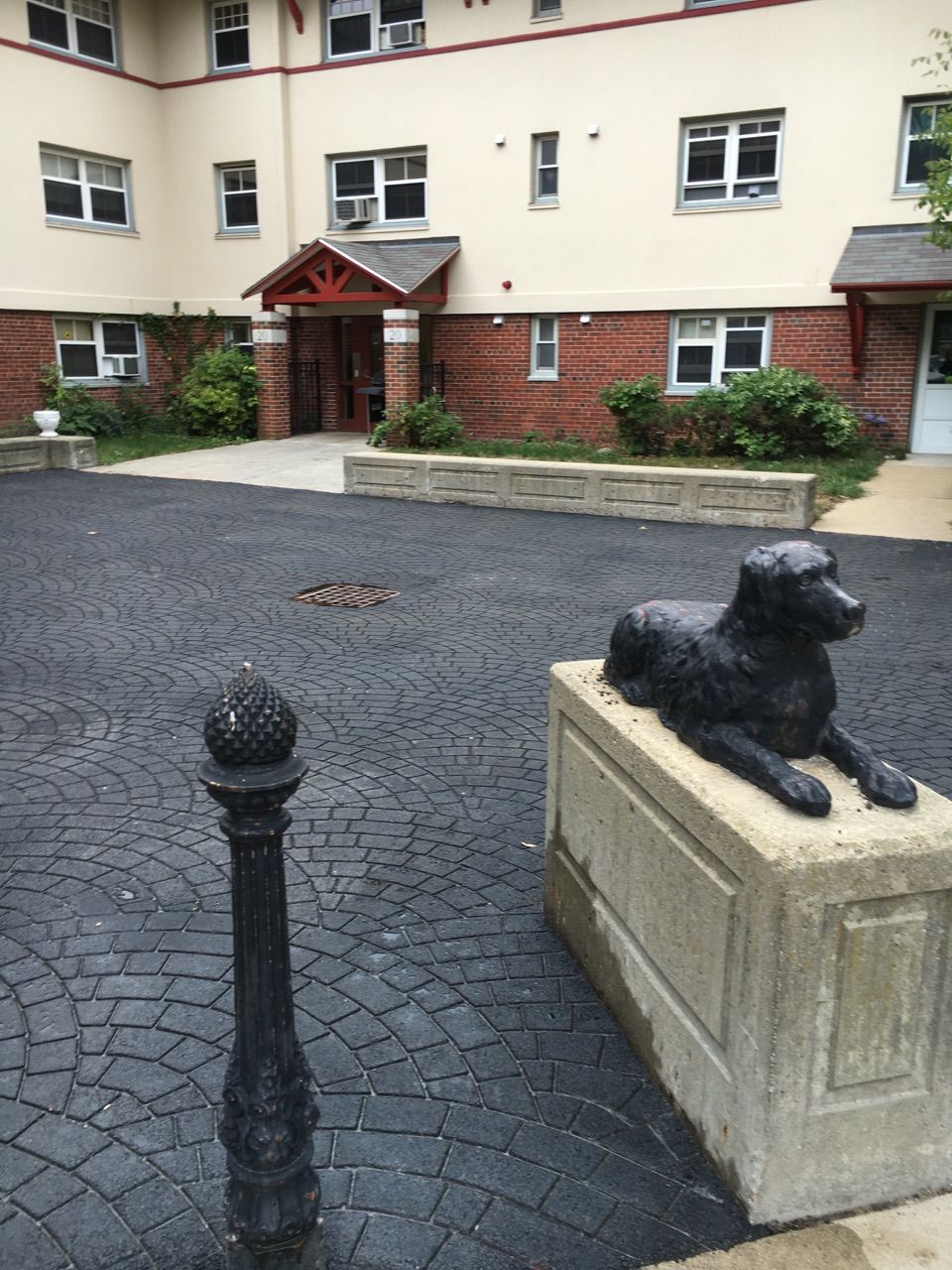 A statue of a dog laying down in front of a building
