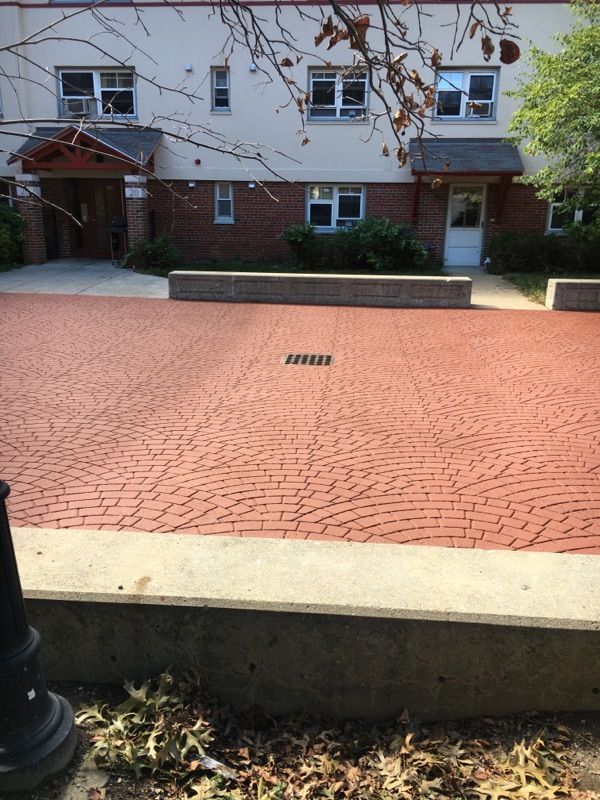 A white building with a red brick walkway in front of it