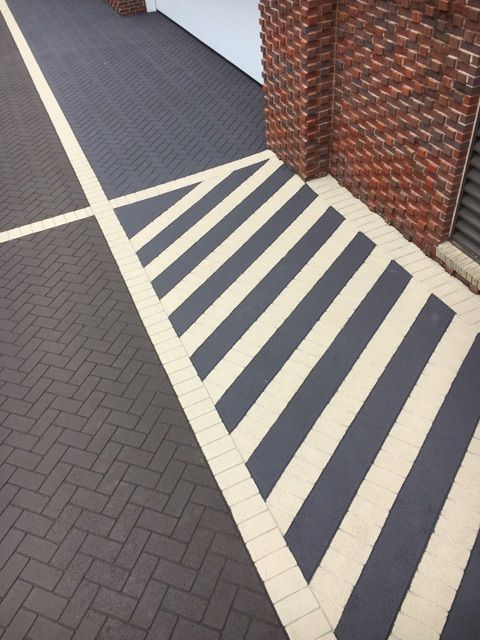 A brick walkway with black and white stripes on it