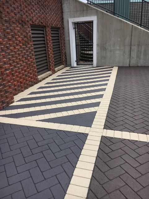 A brick driveway with a staircase in the background