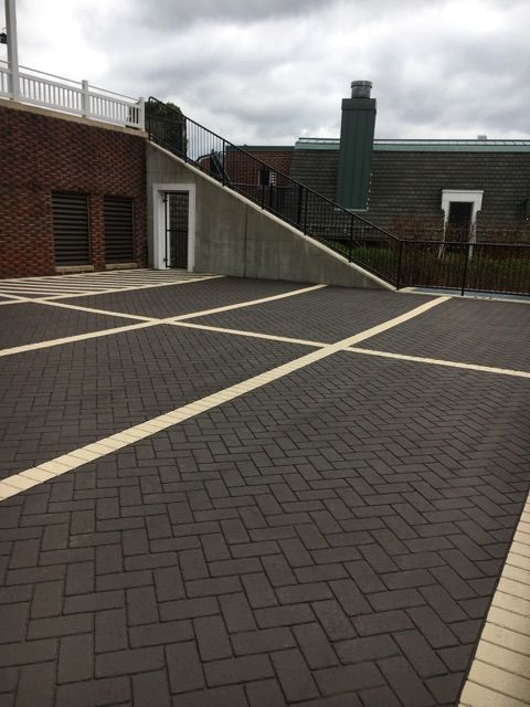 A brick driveway with a brick building in the background