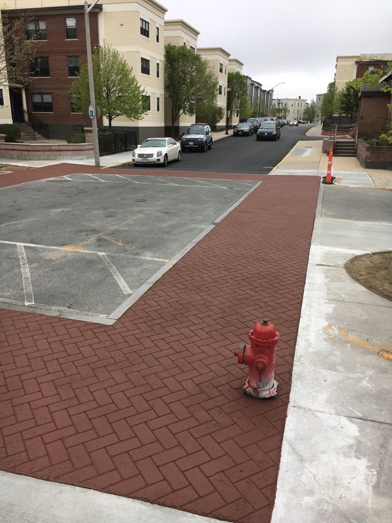 A red fire hydrant is in the middle of a parking lot