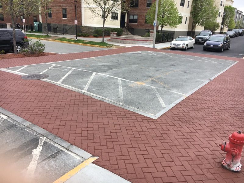 A fire hydrant is in the middle of a parking lot